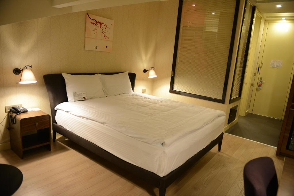 Adana Plaza Hotel في أضنة: غرفة نوم بسرير وملاءات بيضاء ونافذة
