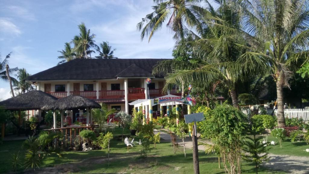 a resort with palm trees in front of it at SUNSHINE PARADISE Inn in Bantayan Island
