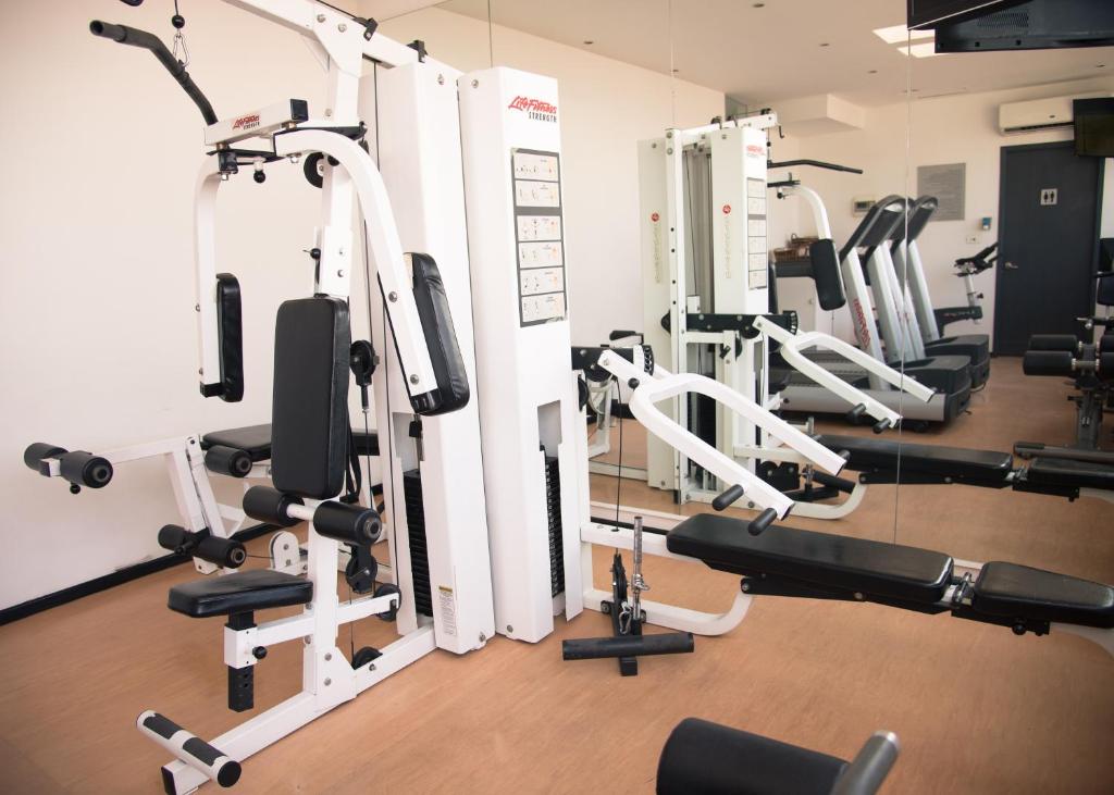 A compact mirrored gym centered on a multi-station strength machine.
