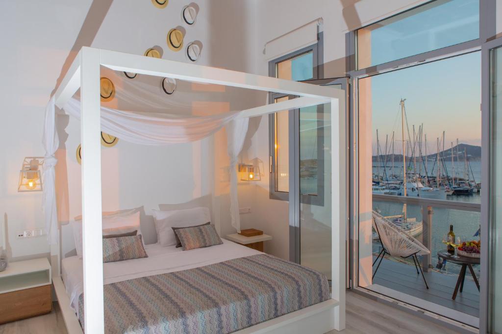 een slaapkamer met een hemelbed en een balkon bij Naxos Riviera Suites in Naxos Chora