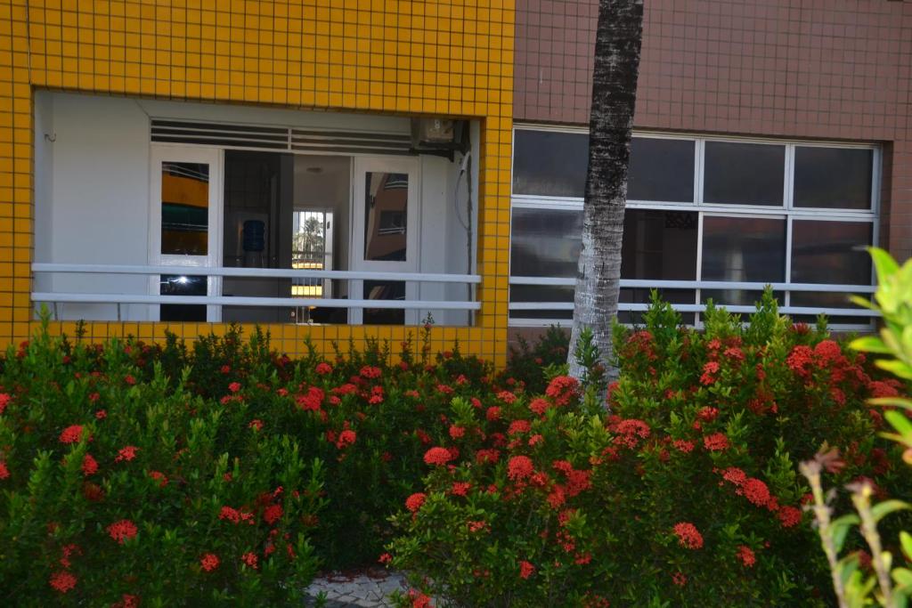 un edificio amarillo con flores delante en Village Cartier, en Fortaleza