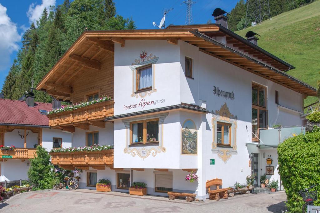 a large white building with a wooden roof at Pension Alpengruss in Gerlos