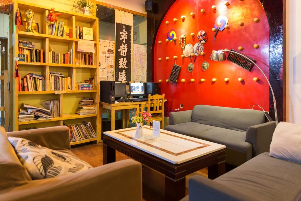 a living room with two couches and a red wall at Shanghai Blue Mountain Bund Youth Hostel in Shanghai