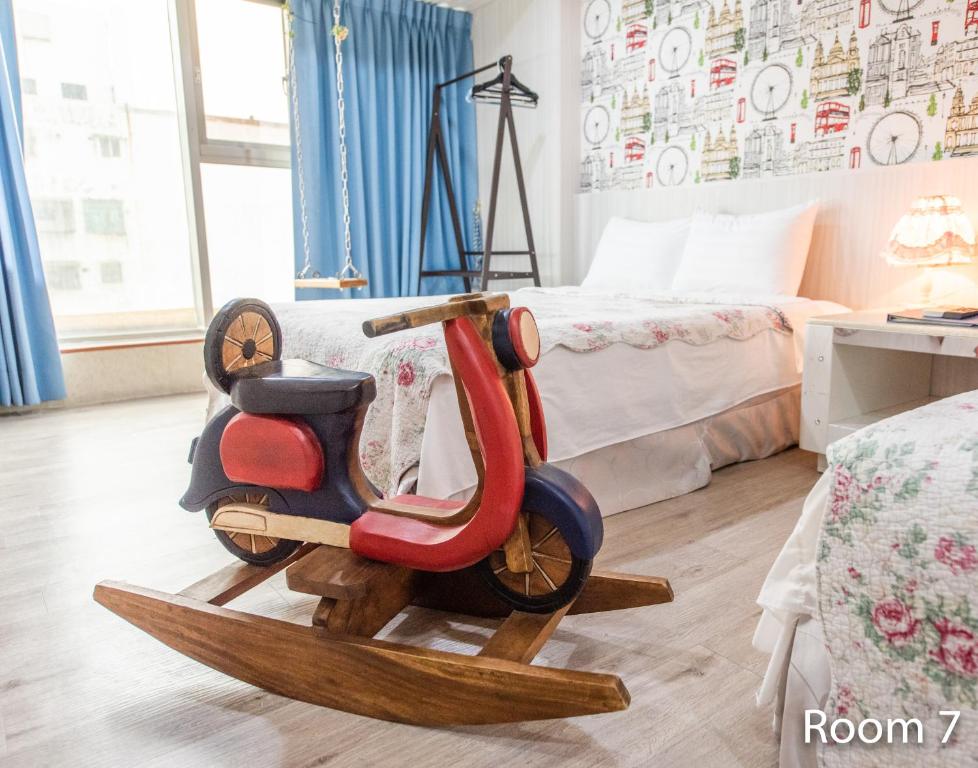 a wooden motor scooter sitting in a room with a bed at Gwawa Hotel in Kaohsiung