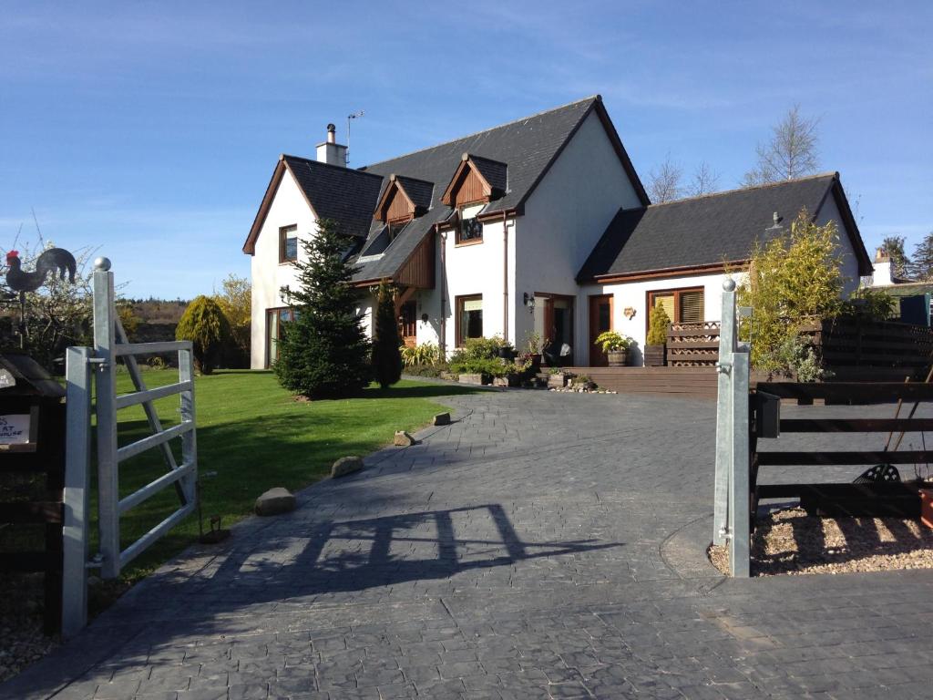 uma casa branca com uma cerca e uma entrada em Old Mills Garden em Elgin