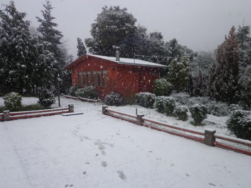 um celeiro num quintal coberto de neve com uma casa em Puelche de Antuco em Antuco