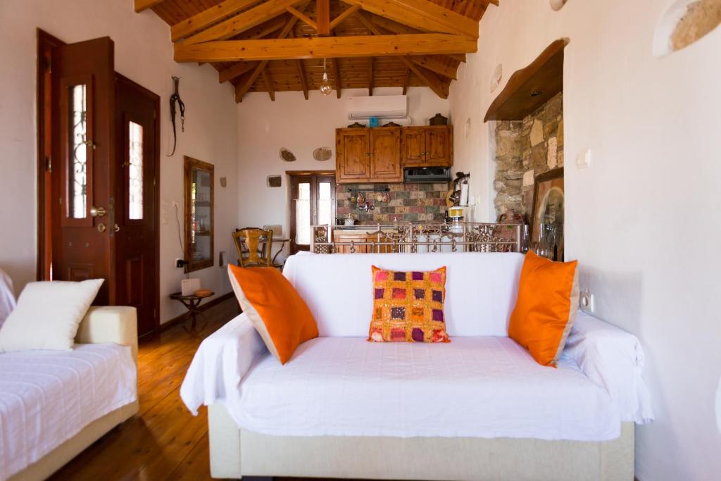 salon z białą kanapą z pomarańczowymi poduszkami w obiekcie Unique breathtaking seaview house w mieście Koumeika