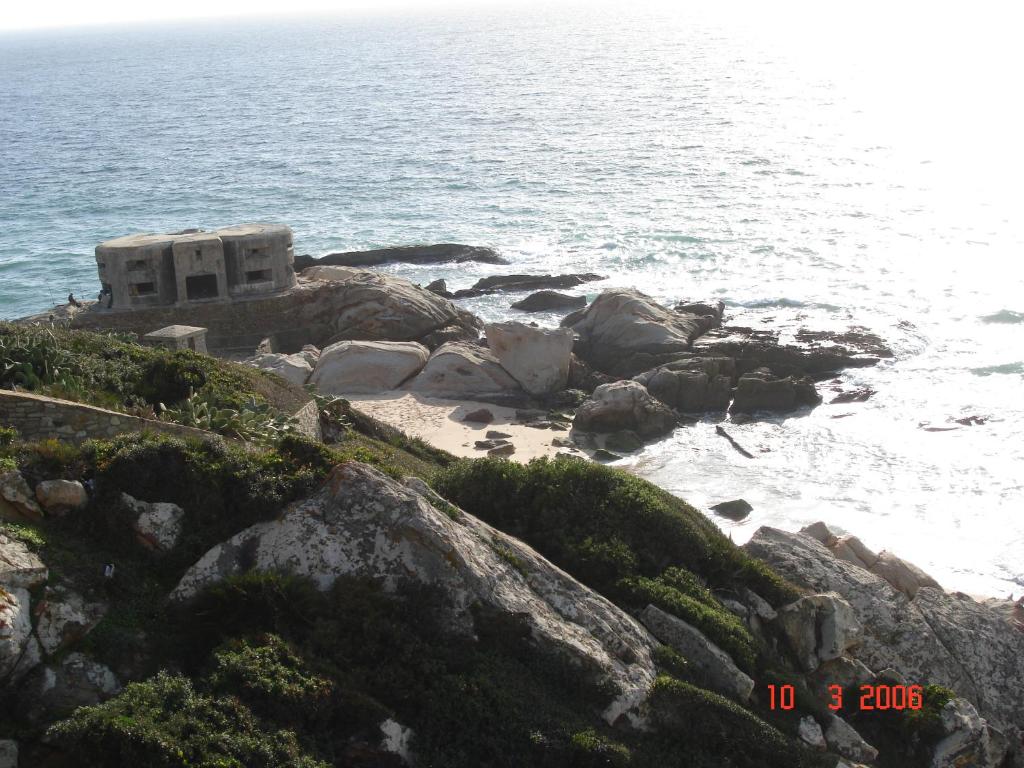 a building on the rocks next to the ocean at Zahara Sol Villas y Apartamentos by QHotels in Zahara de los Atunes