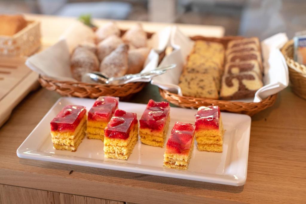 a plate of cakes and pastries on a table at Luxury B&B August in Ortisei