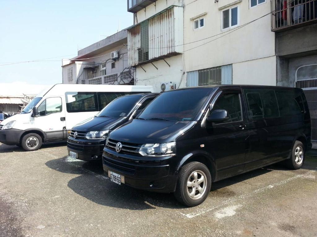 two vans parked in a parking lot next to a building at Apple Tree Bed and Breakfast in Hualien City