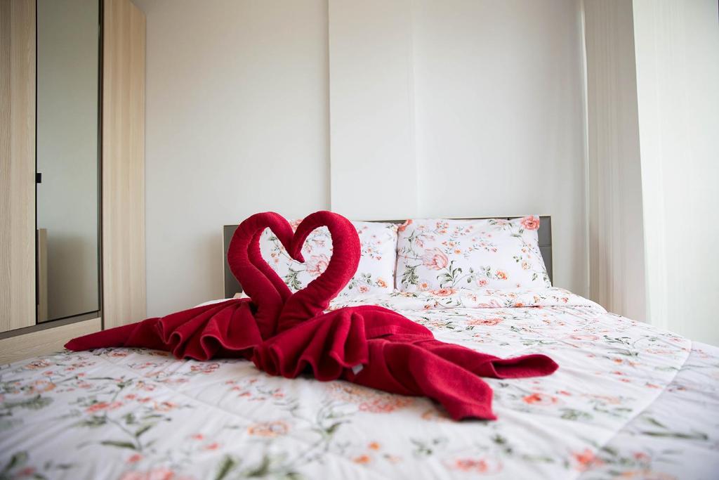 czerwony koc w kształcie serca na łóżku w obiekcie Grand Beach Condo B404 by Malai w mieście Klaeng