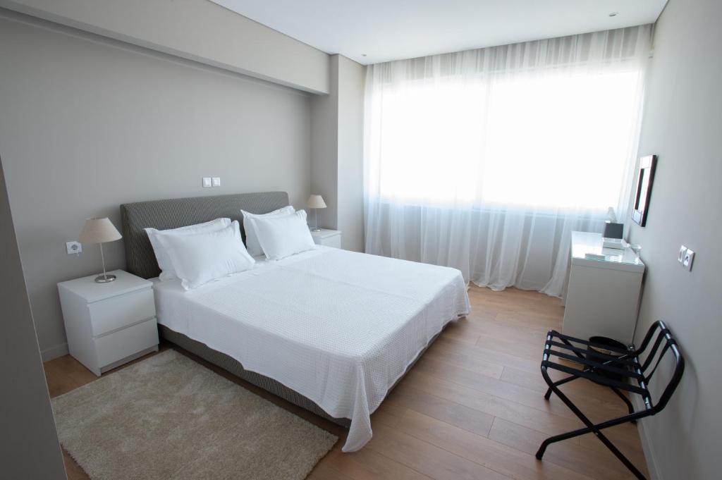 a bedroom with a white bed and a window at Athens Center Panoramic Flats in Athens