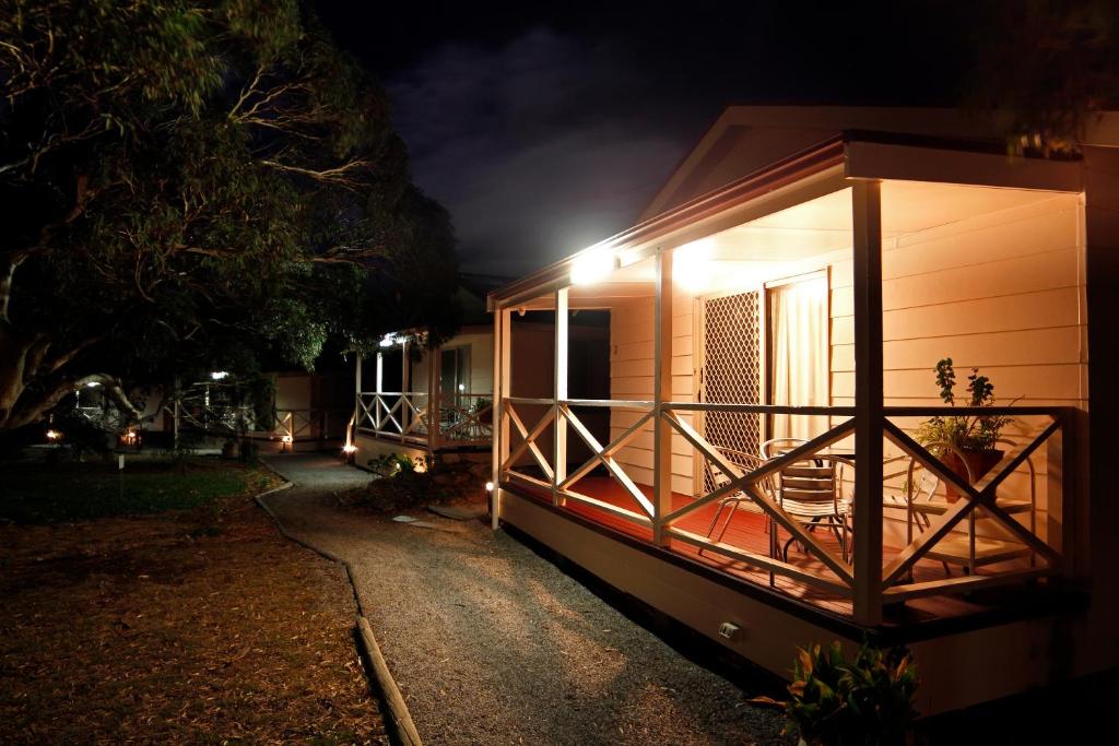 una pequeña casa con porche por la noche en Cape Jervis Holiday Units, en Cape Jervis