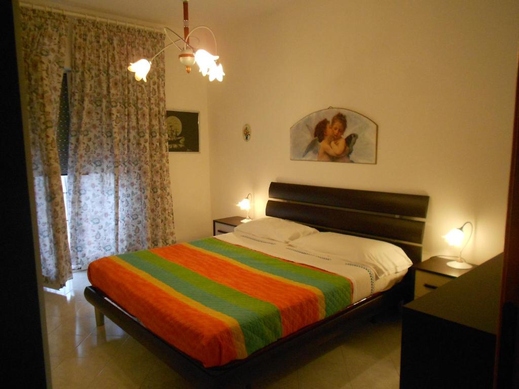 ein Schlafzimmer mit einem Bett mit einer bunten gestreiften Decke in der Unterkunft Casa Magnolia in Gaeta