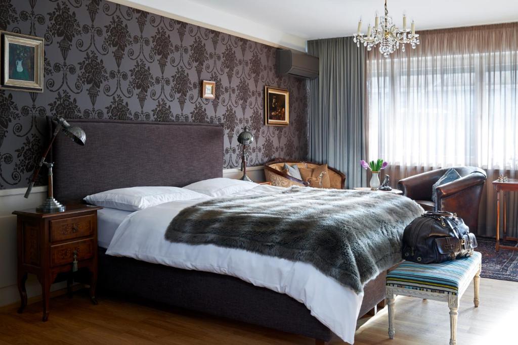 a bedroom with a large bed and a chandelier at Townhouse Boutique Hotel in Zürich