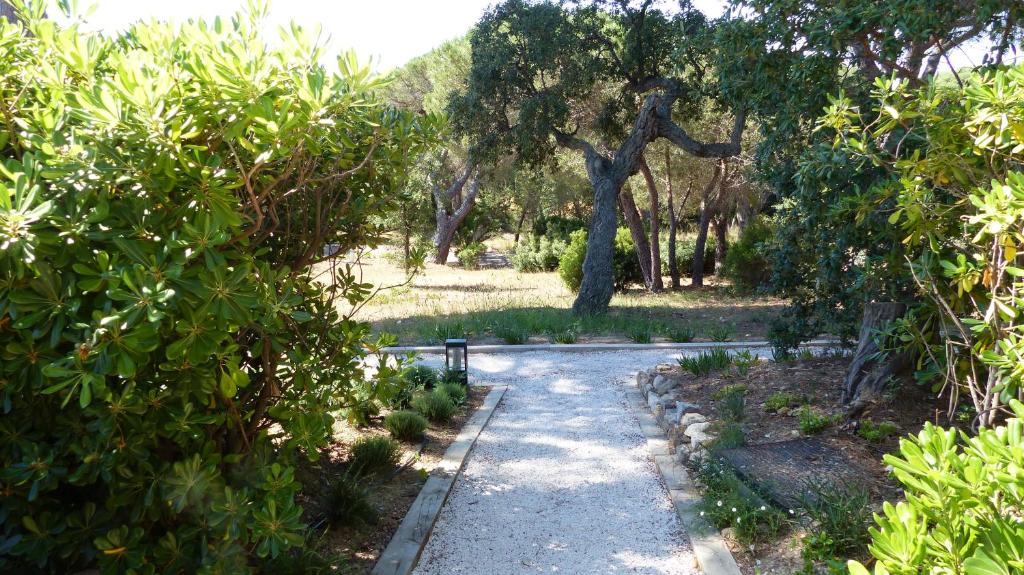 a path through the trees in a park at Hôtel les Bouis - Vue mer in Saint-Tropez