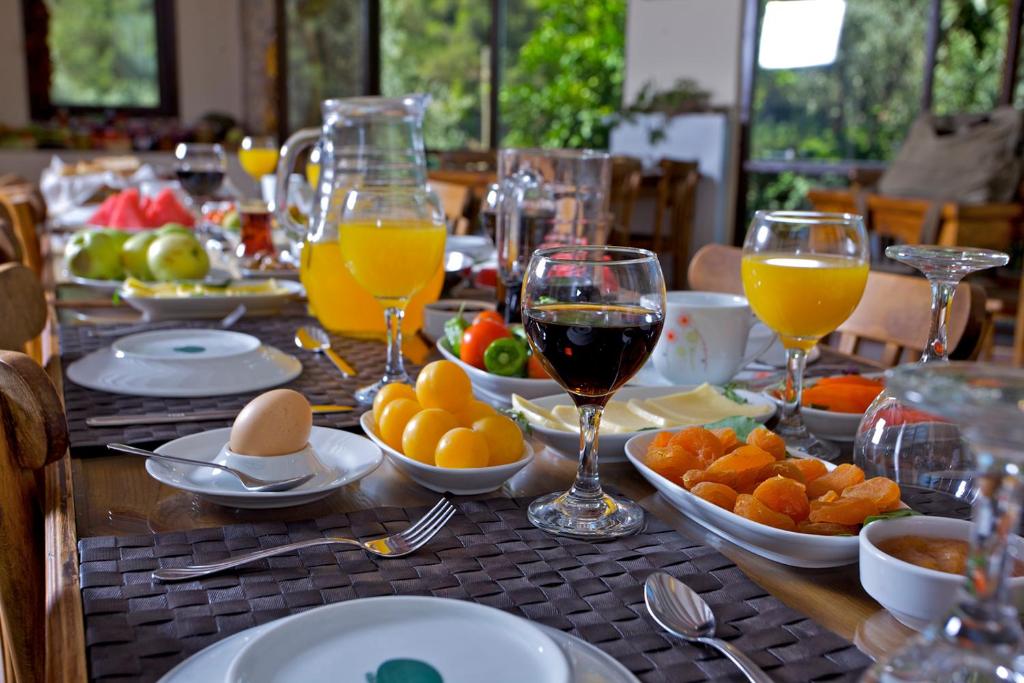 uma mesa com pratos e taças de vinho e frutas em Ephesus Boutique Hotel em Kirazli