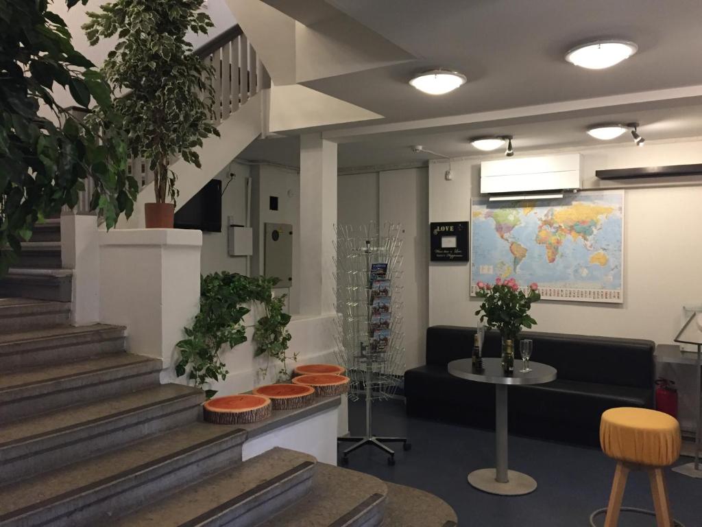 a lobby with stairs and a couch and plants at Freedom65 Hostel and Caravan in Tallinn