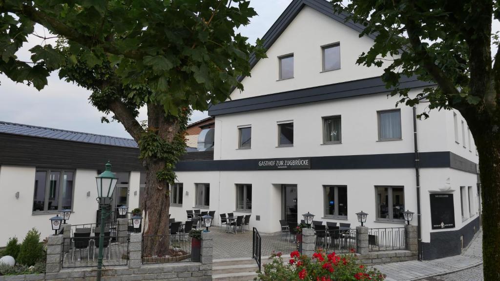 a large white building with tables and chairs at Gasthof Schiefer Zur Zugbrücke in Bad Kreuzen