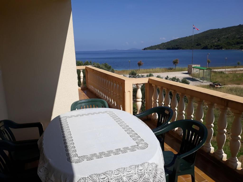 stół i krzesła na balkonie z widokiem na ocean w obiekcie Apartments Sakarun Soline w mieście Soline