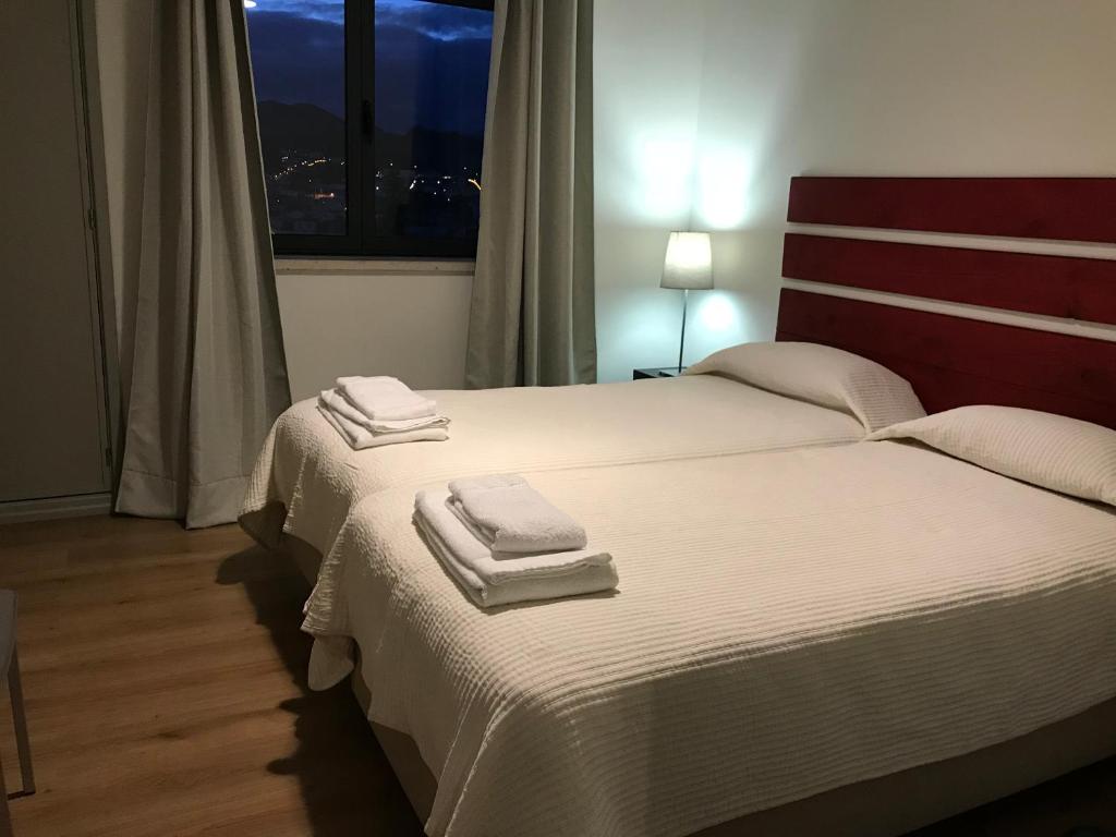 a bedroom with two beds with towels on them at Apartamentos Solmar 15º in Ponta Delgada