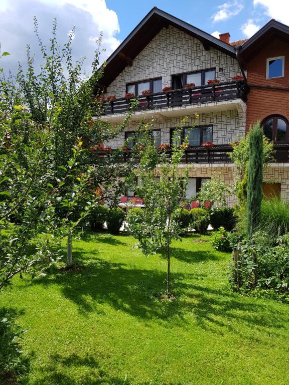 una casa con un cortile verde davanti di Apartment Paradise Enver a Dubrave Gornje