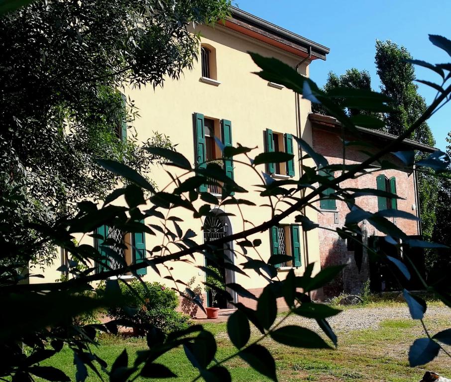 a building with green shutters on the side of it at Il Boschetto di Morgana in Castel San Pietro Terme