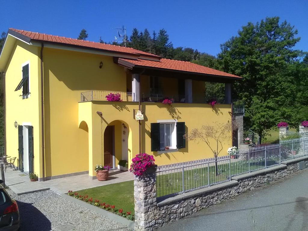 una casa amarilla con flores en una valla en B&B Oasi Verde, en Corvara