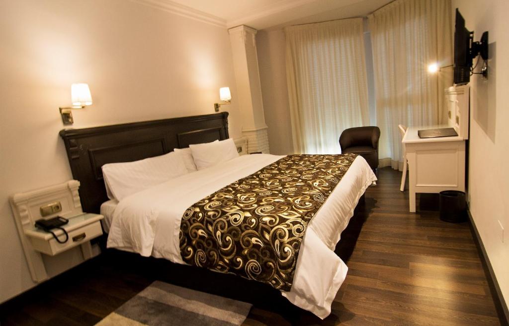um quarto de hotel com uma cama grande e uma secretária em Avent Verahotel em Vera