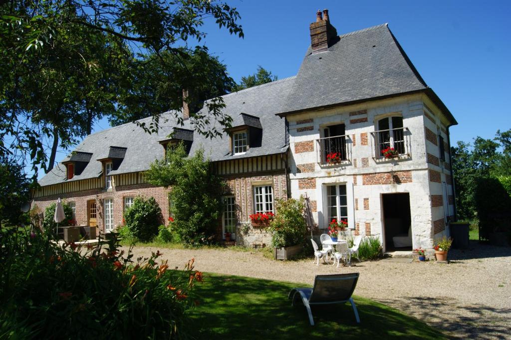 ein großes Backsteinhaus mit grauem Dach in der Unterkunft Gîtes Normands de charme les châtaigniers in Bretteville-du-Grand Caux