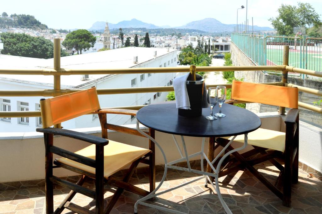 una mesa y sillas en un balcón con vistas en Sky-Line Apartments en Afantou