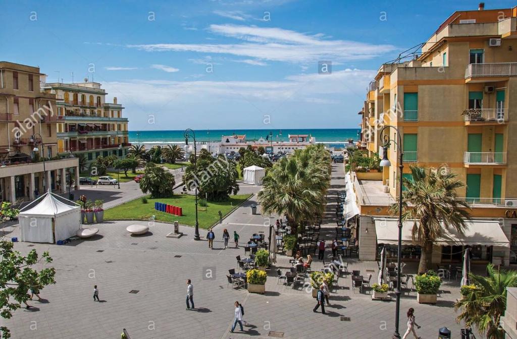 a city with people walking on the street in front of the beach at Domus Lido in Lido di Ostia