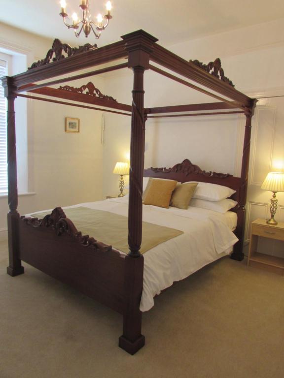 duże łóżko z baldachimem w sypialni w obiekcie Kenmuire Apartment w mieście Weymouth