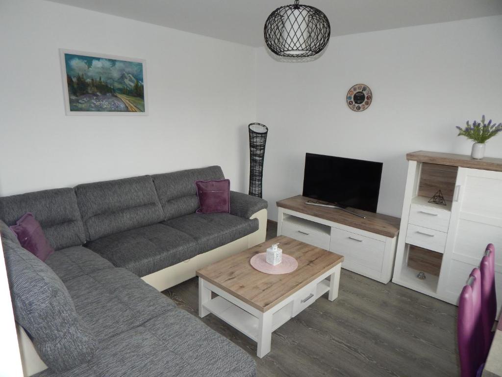 a living room with a couch and a coffee table at Apartmán LEMON in Vysoke Tatry - Tatranska Lomnica.