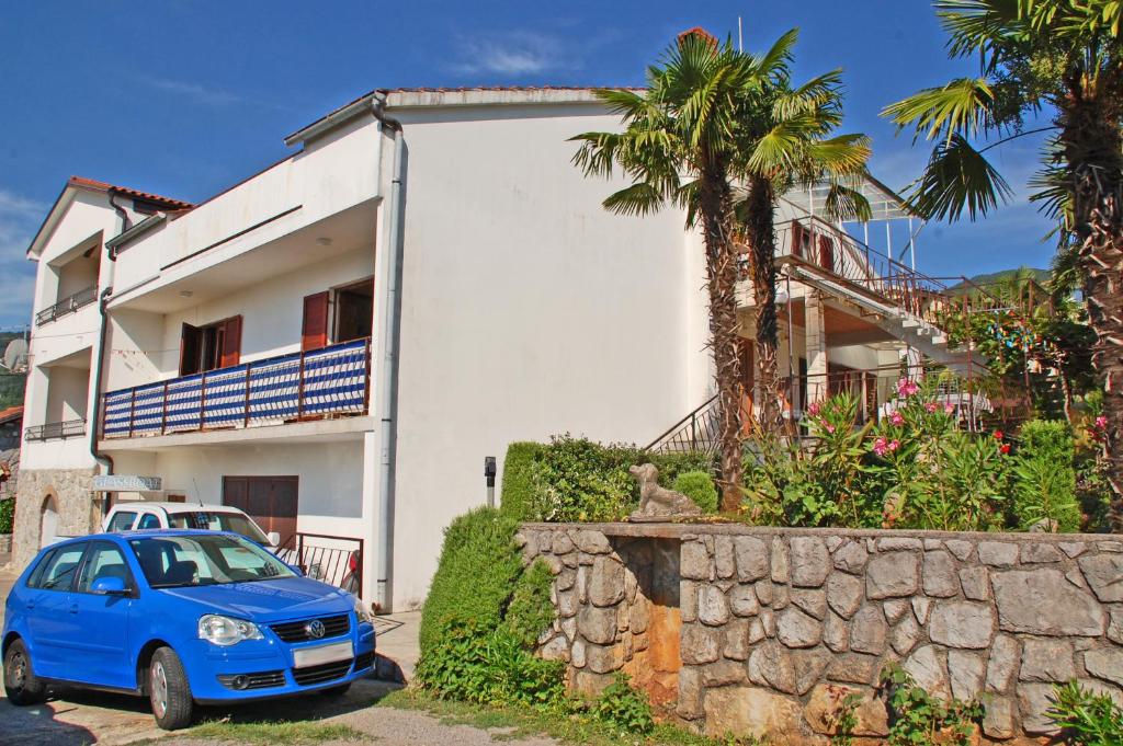 Niebieski samochód zaparkowany przed domem w obiekcie Apartments Miro w mieście Ičići