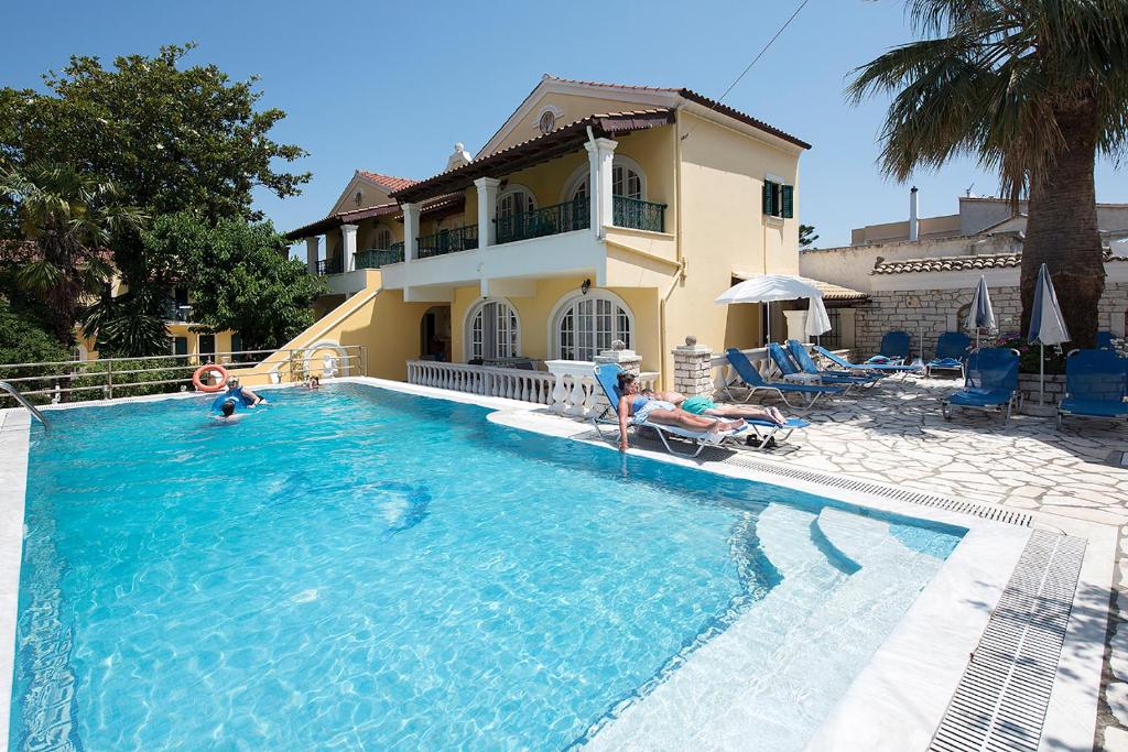 ein Haus mit einem Pool vor einem Haus in der Unterkunft Andreas Pool Complex in Korfu-Stadt
