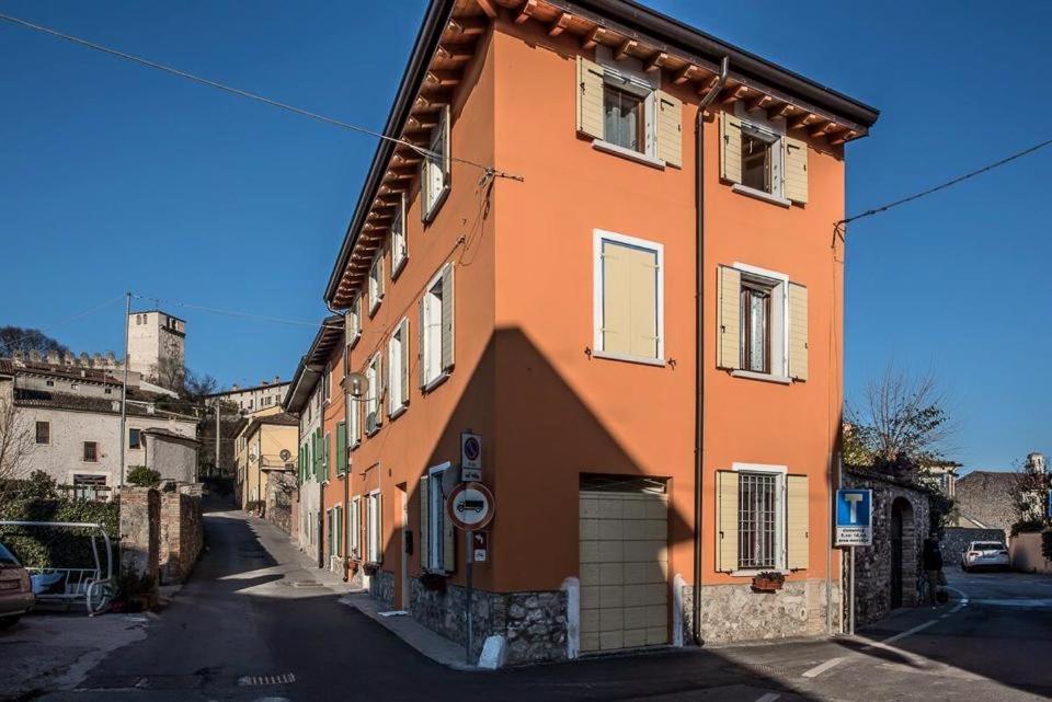 蒙贊巴諾的住宿－B&B AL VICOLO DI MEZZO，一座橙色的建筑,在街上设有车库