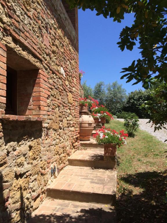 un edificio de ladrillo con escaleras y flores en él en Agriturismo Il Sasso, en Montepulciano