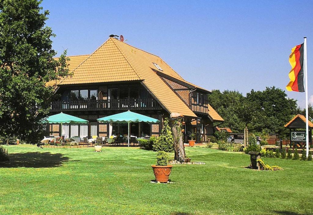 a large building with a roof on a field of grass at Hotel Seewisch in Flessenow