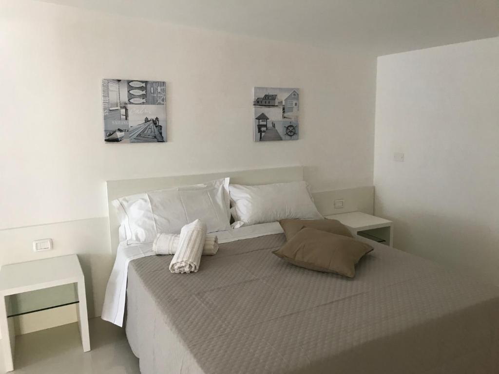 a white bedroom with a large bed with two pillows at Villa Vittoria City in Rodi Garganico