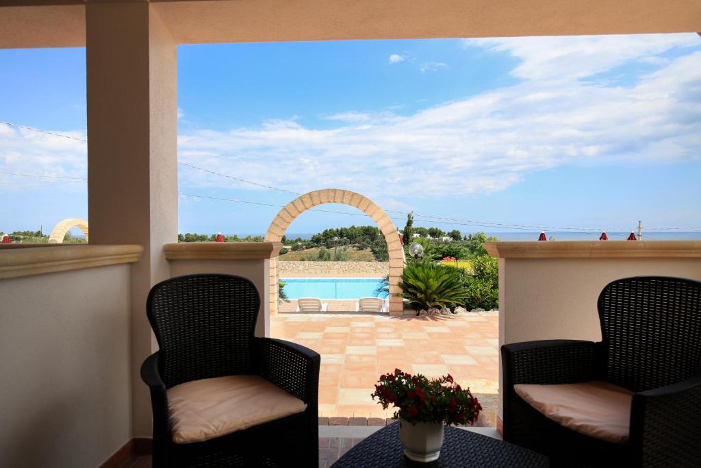 a patio with two chairs and a view of a pool at B&B Hibiscus in Vieste