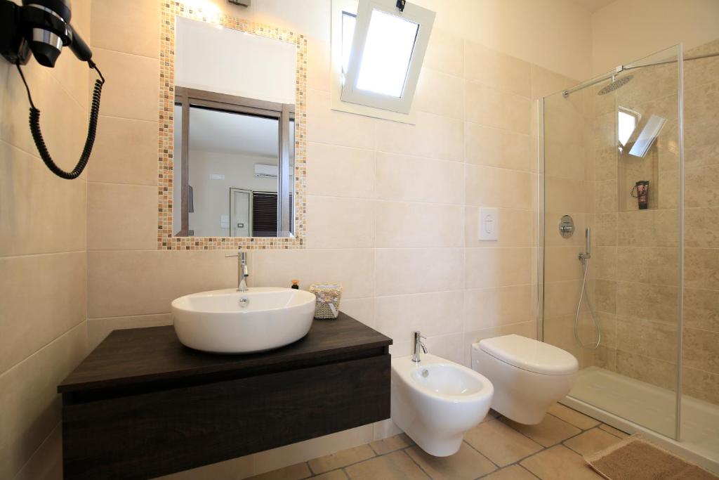a bathroom with a sink and a toilet and a mirror at B&B Hibiscus in Vieste