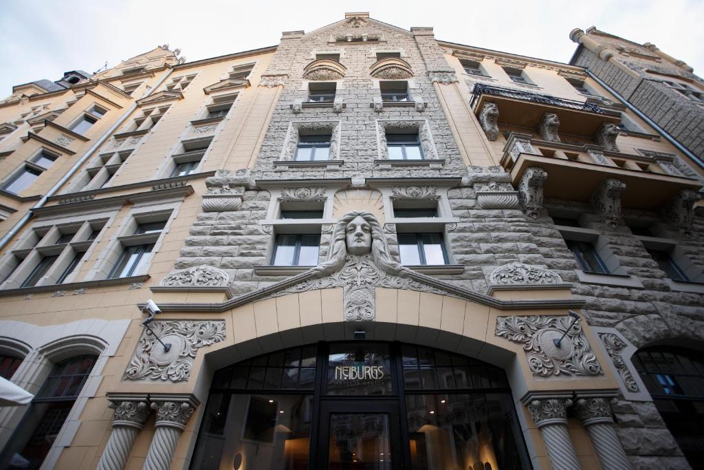 a large building with a clock on the front of it at Neiburgs Hotel in Riga