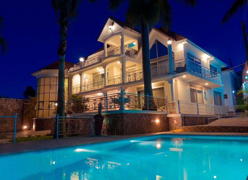 a large white house with a swimming pool at night at Ivory Castle Limited in Kampala