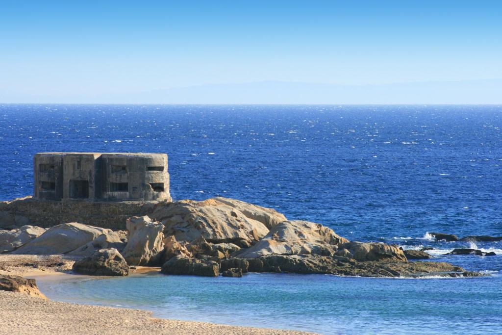 a small building on a rocky island in the ocean at Zahara Sol Villas y Apartamentos by QHotels in Zahara de los Atunes