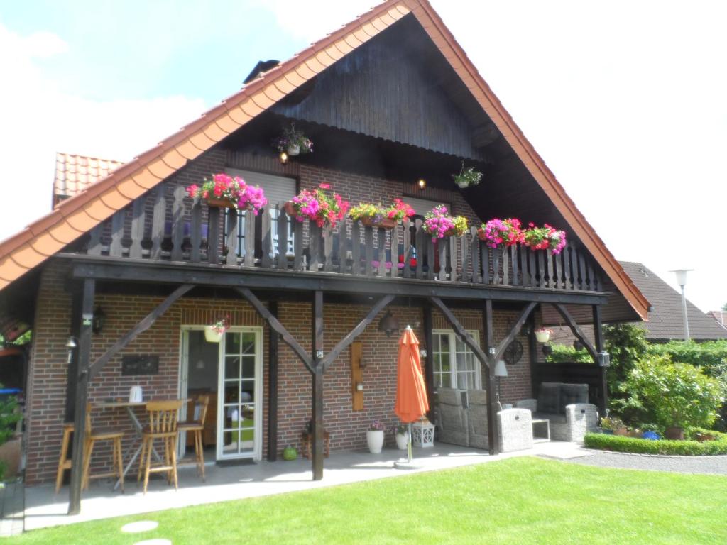 una casa con un balcón con flores. en Appartement am Stadtpark en Ochtrup