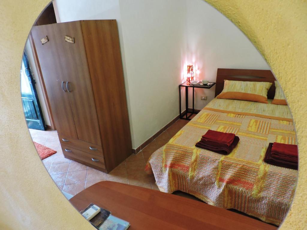 1 dormitorio con cama, tocador y espejo en Etna Hiking B&B, en Trecastagni