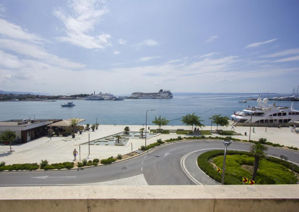una carretera junto al océano con barcos en el agua en La Bayadere, en Split