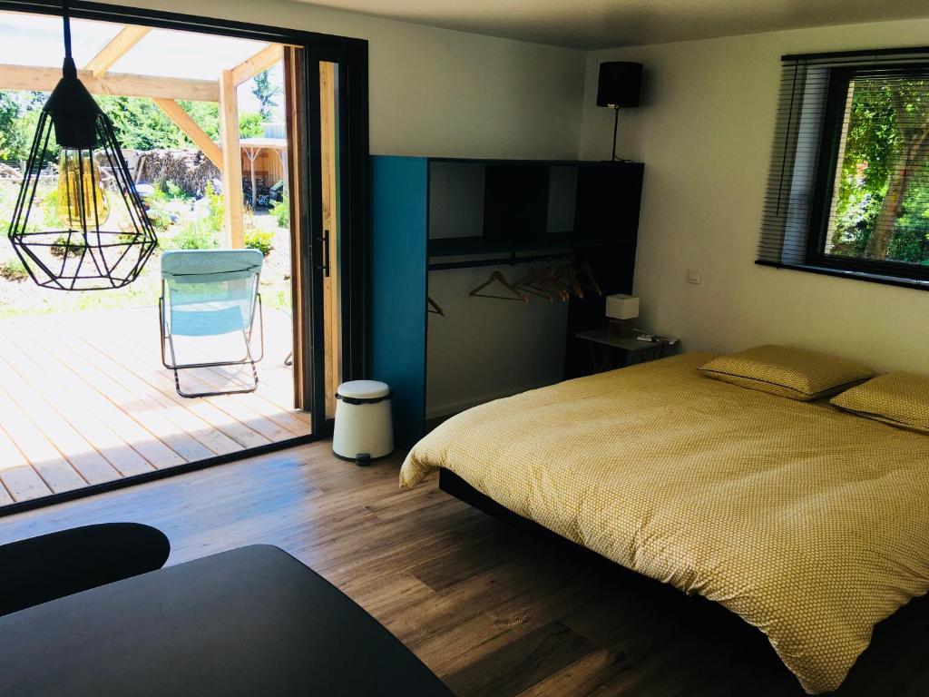 a bedroom with a bed and a door to a patio at Les Chambres d&#39;Hôtes de Bordustard in Le Palais