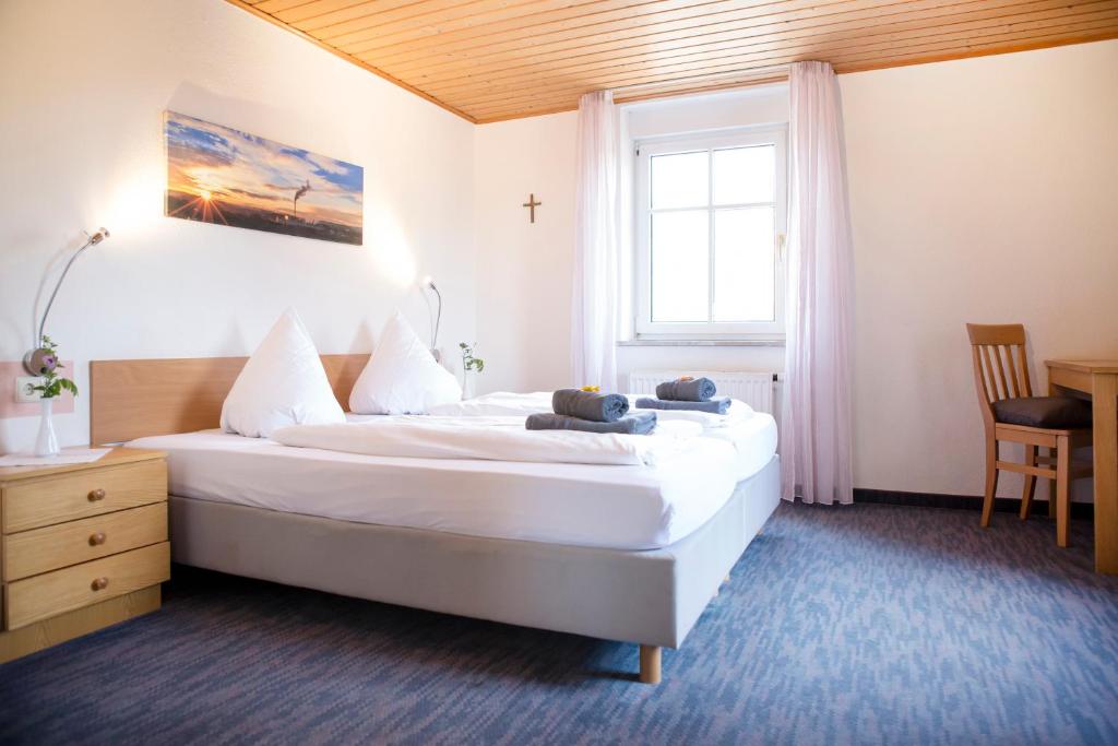 a hotel room with a large bed and a window at Gasthof Knupfer in Ehingen